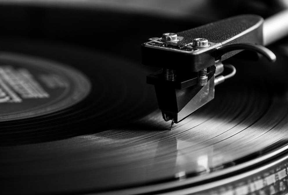 Agulha de gira-discos a tocar um vinil, em fotografia a preto e branco